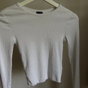 Vit långärmad  - Långärmad topp med öppning vid ryggen, ej använd.