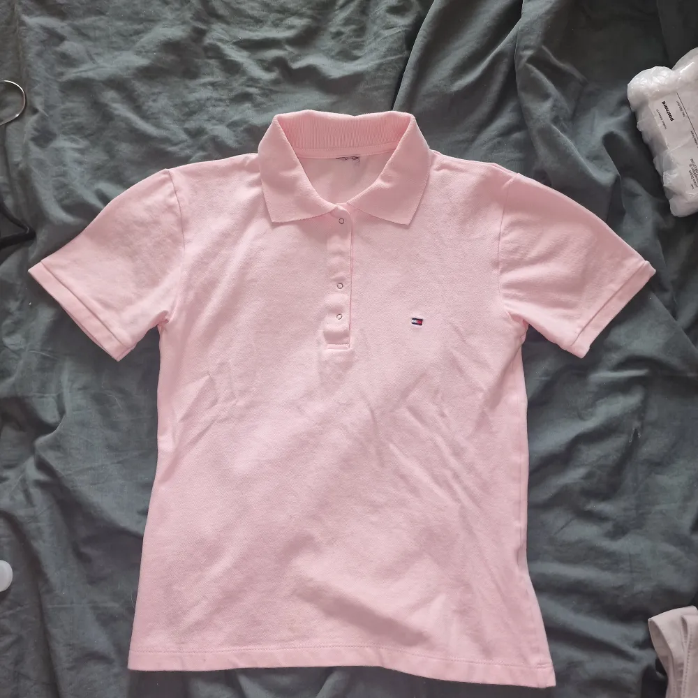 Polo tröja från Tommy Hilfiger, lappen klippt samt en knapp som är trasig som går att laga (se sista bild) därav priset🦋. Tröjor & Koftor.