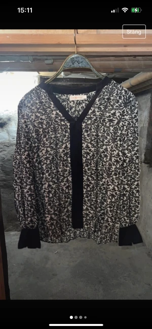 Tory Burch skjorta.  - Tory Burch skjorta.  Storlek 2 skulle gissa på storlek 34/XS/6 Färgen är en blandning av svart, vit & grått. Några funderingar/frågor fråga på. 