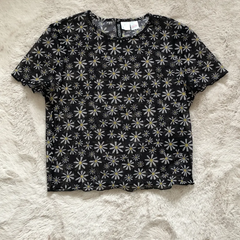 En blommig ”genomskinlig” svart t-shirt som är skön på sommaren . Toppar.