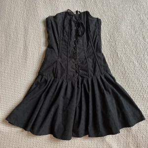 Klänning  - Punkig axelbandslös klänning med korsettsnörning. 🖤