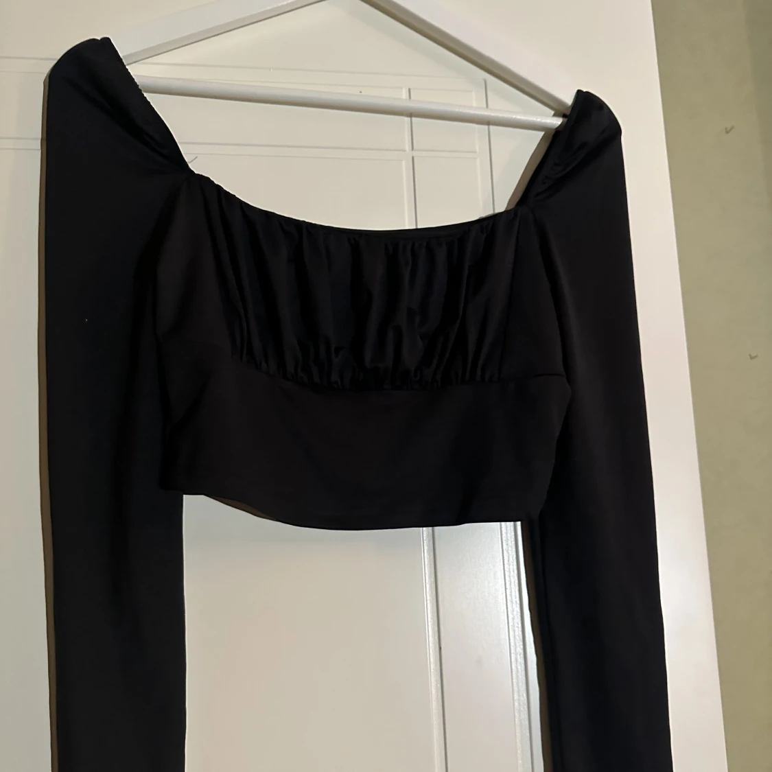 Svart topp med rynkor framtill