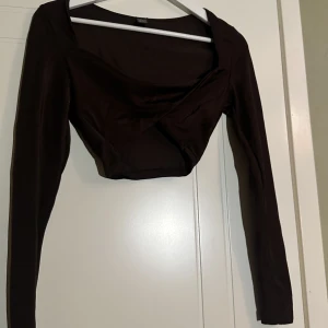 Toppar med vridning framtill  - Säljer min bruna, gröna och lila topp med vridning framtill. Stretchig och använd 1 gång. Fint skick! 1 för 90, 2 för 150 och alla för 200kr. 