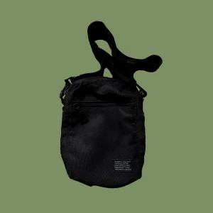 Liten axelremsväska - Liten axelremsväska med justerbar rem. Dragkedjan är lite trasig. Men annars i bra skick. Perfekt på sommaren att ha telefon, plånbok etc i. 