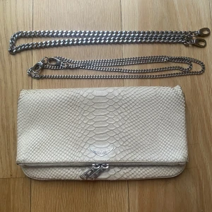 Zadig & Voltair Väska - Säljer min jätte fina Zadig väska då den tyvärr inte kommer till användning längre😇😇 Väskan är vit och croco prägldad, den är använd men fortfarande väldigt fin! Två kedjor silverkedjor ingår en lång och en kortare. Köpt för 4000kr