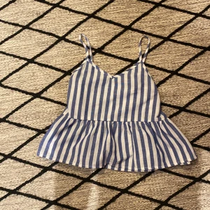 Randig topp med volang - Blå vit randig topp/linne från SHEIN i mycket fint skick. Stl 10 år med justerbara axelband 