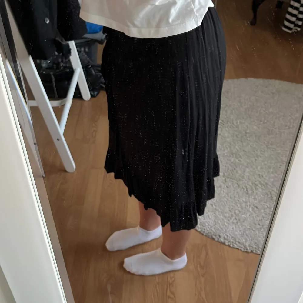 Svart medellång kjol från Lindex med volang i stl XS☺️. Kjolar.