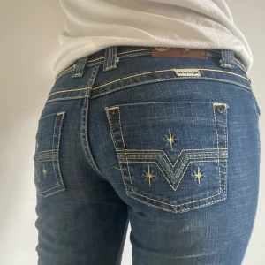 Lågmidjade Jeans - Intressekoll på dessa snygga lågmidjade jeans med detaljer. Köpta secondhand så vet ej va de är för märke, jeansen går ner till fötterna på mig som är 1.70