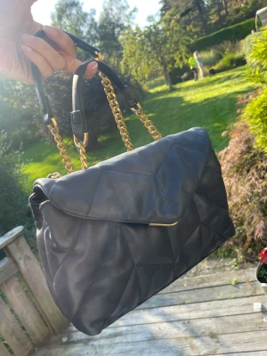 Mango svart axelremsväska  - En snygg väska med medföljande längre band. Har lite guldiga detaljer och köpte från zalando förra hösten. Använder den inte längre och därav säljer jag den. Knappt använd🎀🦋🩷