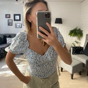 Blommig topp - Blommig topp med fin skurning vid bysten. Använd ett fåtal gånger men har inga anmärkningar.