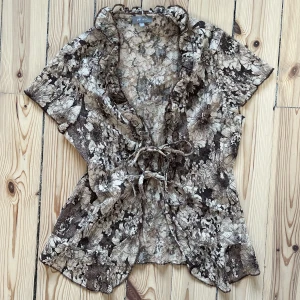 Söt spetstopp! - En gullig topp som stängs med snören. Spets, lite volang och blommönster! 