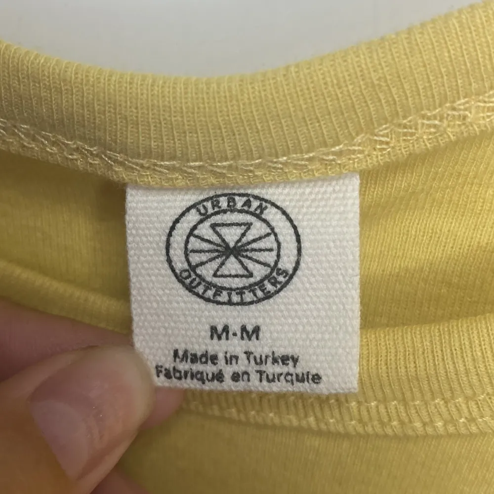En gul somrig T-shirt med tryck av blomma på från Urban outfitters. Tröjan är i bra skick och är endast använd fåtal gånger🤍Storleken är M men skulle säga att den passar alla som är XS - M. T-shirts.