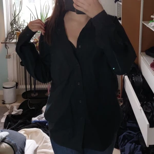 Svart skjorta - Super snygg lagom oversized svart skjorta♡ Älskar hur den sitter men säljer pga att den har en grön underton, har inga defekter och köptes för 60 kr och den är ca 74 cm lång.  KOLLA BIO!!!
