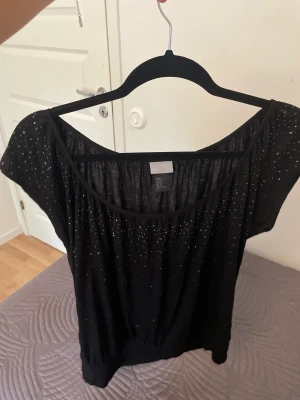 Svart glittrig tröja - Svart tröja med paljetter på ärmarna och vid bröstet, så fin.