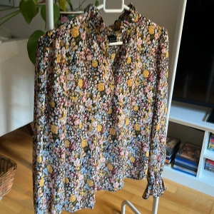 Volangblus för vardag och fest - Romantisk och oanvänd blus med fin krage och liten volang på ärmen.   Passar lika bra till ett par jeans som till kjol eller tights. 