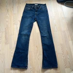 Utsvängda mörkblå jeans från Lindex i modellen Karen. Mid waist. De är lite slitna vid bakfickan och längst ned. Storlek 38 men känns mindre.