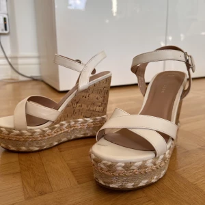 Kilklackar - Vita kilklackar, sparsamt använda, men har en fläck på vänster sko där stortån ska vara. 