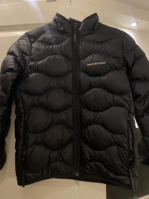 Peak performance jacka - Peak performance jacka för barn i strl 150 skulle säga denna jacka motsvarar en person som skulle kunna ha Xs i storlek. Knappt använd och är i nytt skick, inga defekter.  Nypris är strax över 2000kr