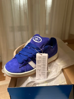 Adidas Campus 00s - Helt oanvända Adidas Campus 00s sneakers i färgen blå. Skorna är storlek 38 2/3. Kommer med tre skosnören. Har kvitto 2100 kr