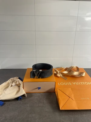 Louis Vuitton Bälte - Säljer detta Louis Vuitton bälte i storlek 85cm, bältet är i bra skick endast ett hål som är skadad se sista bilden! Bältet kommer med box, dustbag samt Louis Vuitton påse. 