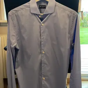 Ljusblå skjorta från Tiger of Sweden. Storlek: 38 Slim  Använd enstaka gånger, nyskick Modell: Farell 5 färg: 208 Nypris: 1299kr