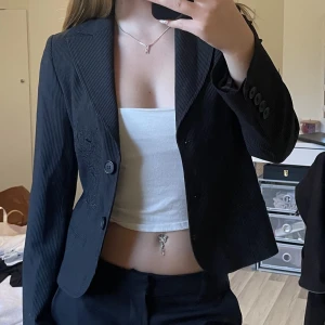 Kavaj - Kavaj med broderad blomma som detalj