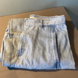 Denimbyxa, hög midja Cos - Ljust blå denimbyxa med hög midja och vida ben. Fint material som ger tyngd och snyggt fall. Mycket lite använda och i mycket fint skick. 