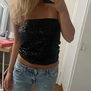 Paljett bandeau topp - Säljer en jättefin svart paljetttopp köpt second hand! Mycket fint skick. Perfekt festtopp!