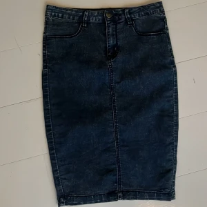 Stretchig tight jeanskjol - Snygg och skön jeanskjol i stretchigt ganska tunt jeanliknande tyg. Slits bak. Storlek 36. Längd 55 cm. Aldrig använd. 