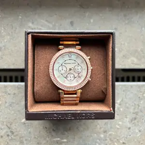 Michael Kors Parker Vit/ Roséguldstonat stål 39 mm.  Fick den i present och har max använt den 1-2 ggr. Utmärkt skick. Jag la märke till att den har en jätte liten skråma på glaset men den är svår att se med blotta ögat. Länkar medföljer. Nypris: 2995 kr