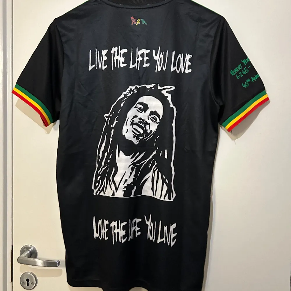 Svart Bob Marley X Ajax fotbollströja med massa olika ikoniska Bob Marley citat. Helt ny i storlek S.. T-shirts.