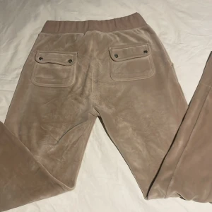 Juicy couture byxor  - Hej! Säljer mina juicy byxor i beige för ett bra pris. Rätt så använda men i bra kvalitet. Ingen knapp är borta eller så. Dock är dom fållade (uppsydda) men det är borta nu så dom är i normal längd. Skriv vid frågor, säljer även överdelen🩷
