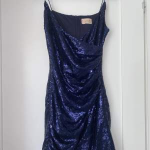En mörkblå paljettklänning från märket Club London utan några större tecken på användning, är en strl 40 översatt från UK storlekar men passar mig som vanligtvis är S-M