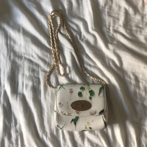 Handväska  - Säljer nu min vit blommiga handväska, är lite smutsig (se bild 3). Vet inte riktigt vart den är ifrån, men det finns en ”logga” inuti kontakta mig för att se bild, men jag tror att det är typ Glitter.