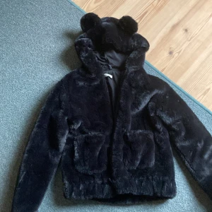 Tunn jacka - En fin svart fluff jacka aldrig andvänd, gulliga öron på luvan. Köpt för 400kr