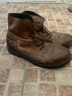 Hilfiger kängor  - Brun skinnkänga med snörning från Tommy hilfiger, kan behöva putsas upp då dessa stått i garderob i flera år. Skicket är fint men repor finns på tårna!