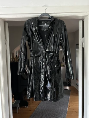 Regnkappa - Ascool lack-regnkappa ifrån Rains! Tyvärr för liten för mig men verkligen så snygg, stänger med dragkedja men finns knappar och knytning. Storlek XXS-XS men skulle säga att den även passar S!
