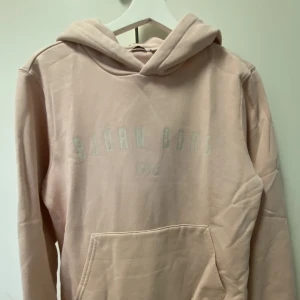 Rosa Hoodie - En ny Björn Borg Hoodie! Den är ljusrosa, färgen blev inte bra upptaget på bild!  Nyskick, har använt den enstaka gånger!  Den är i Stl M, men är ganska liten i storleken! Så passar även S/XS (Har även matchande mjukisbyxor om man vill köpa till
