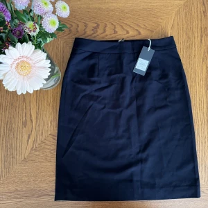 Oanvänd svart kostymkjol - Helt ny kostymkjol från Alice Bizous! Säljes då den är lite tajt på mig som annars bär s/m i kjolar