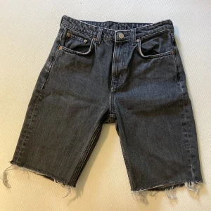 Jeans shorts - Byxor från Weekday, ”seattle trotter black”, avklippta till shorts. Fransiga i ändarna. Storlek i midjan: 26. Välanvända med små synliga slitningar.