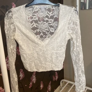 Topp - Vit topp med genomskinlig, spetsig rygg från newyorker. Är i nyskick då den endast är tvättad och testad! 