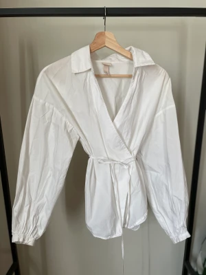 Vit skjorta - Vit omlott skjorta från H&M. Storlek 36. Använd men i fint skick, inget märkbart slitage. 