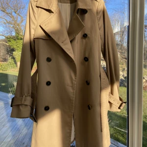 Trenchcoat  - En beige trenchcoat från hm. Knappt använd. Storlek 34