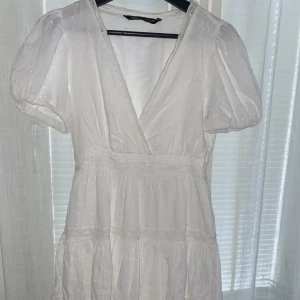 Vit spetsklänning  - Kort vit sommarklänning från Zara i nyskick endast använd två gånger. Är normal i storleken.  Perfekt till student och skolavslutning!