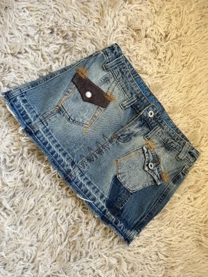 Minikjol i jeans  - Snygg minikjol i jeans, perfekt till sommaren med ett vitt linne till.  37 cm i midjan, 30 cm lång 