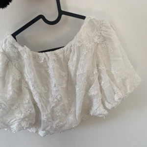 Somrig topp - En blommig fin topp från NA-KD. Har puffärmar. Strl 36