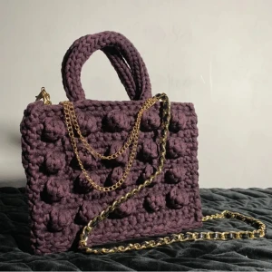 Bucket bag - Virkad väska i en djupt lila färg, som kan bäras både med och utan kedja. Virkad med bommullgarn från textilindustriernas rester.  Mått: höjd:19cm, längd:24cm, djup:11,5cm  OBS! Katter finns i hemmet