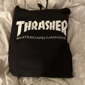 Säljer min svarta thrasher hoodie med vit text. Den är i fint skick förutom att snörena är avklippta och att den Tyvörr har två små hål på fickan, syns inte på håll. Trycket är fint. 💓stl 38