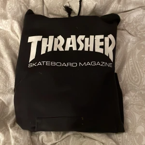 Thrasher - Säljer min svarta thrasher hoodie med vit text. Den är i fint skick förutom att snörena är avklippta och att den Tyvörr har två små hål på fickan, syns inte på håll. Trycket är fint. 💓stl 38