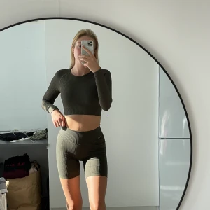 Träningsset - Khaki / mörk grönt tränings set från aim’n. Shortsen är XS och långärmade tröjan S men ganska tajt. Tröjan är endast testad, shortsen är välanvända men i bra skick.  Kan tänka mig sälja endast tröjan